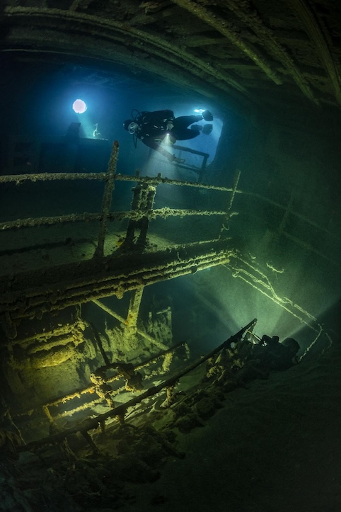 Diver inside the wreck with the name Elviscot with the machine room visible and some lights installed, dive site: Pomonte, Island of Elba, Tuscani, Italy, Mediterranean Sea. All images with the support of AQUANAUTIC ELBA (www.aquanautic-elba.de). Model releases available.